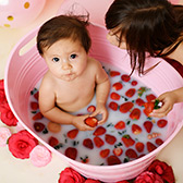 One year old girl takes a strawberry milk bath while big sister watches in Sacramento studio