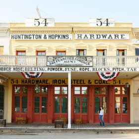 High school graduate posing in front of Huntington and Hopkins Old Sacramento storefront