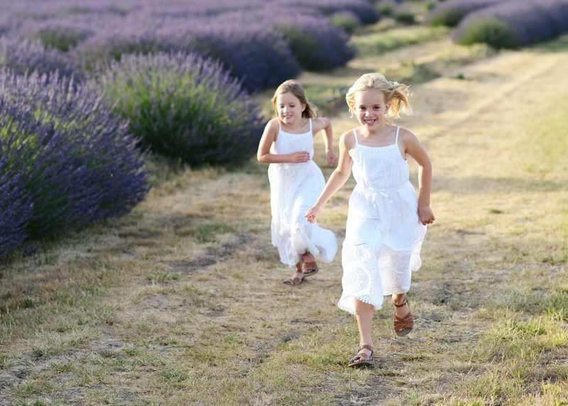 Sisters run along dirt path by lavender field in Araceli Farm Dixon
