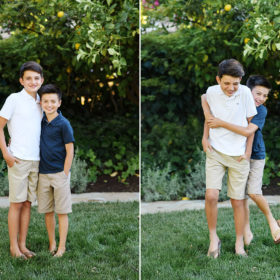 Brothers hug each other and smile in their backyard with lemon tree in Sacramento home