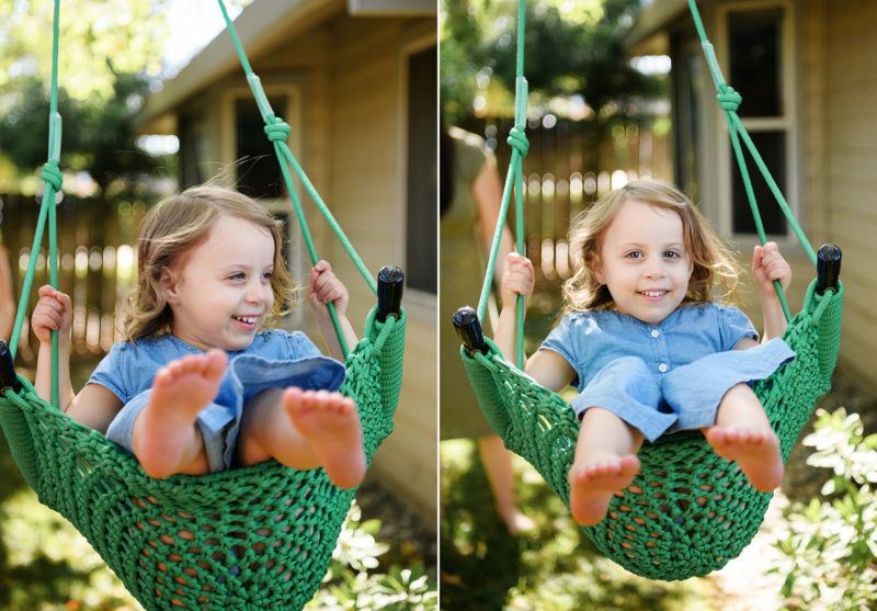 Toddler girl swings outside in Sacramento home backyard