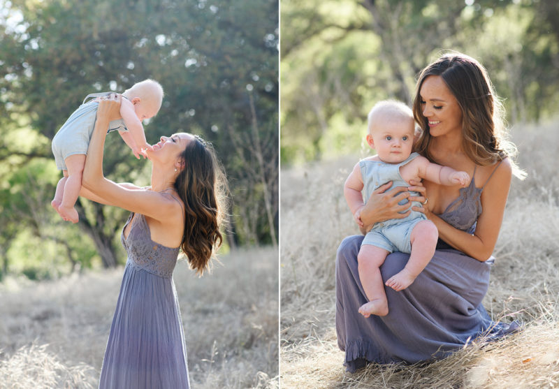 Mom lifting up baby boy and smiling at him while standing in dry grass in Davis