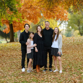 Family surrounded by fall foliage trees in Sacramento
