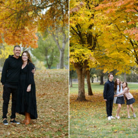 Mom and dad wearing black and hugging and kids hugging while standing on fall leaves and surrounded by foliage Sacramento
