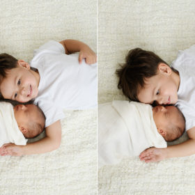 Big brother lying next to newborn baby sister on white blanket in Sacramento studio