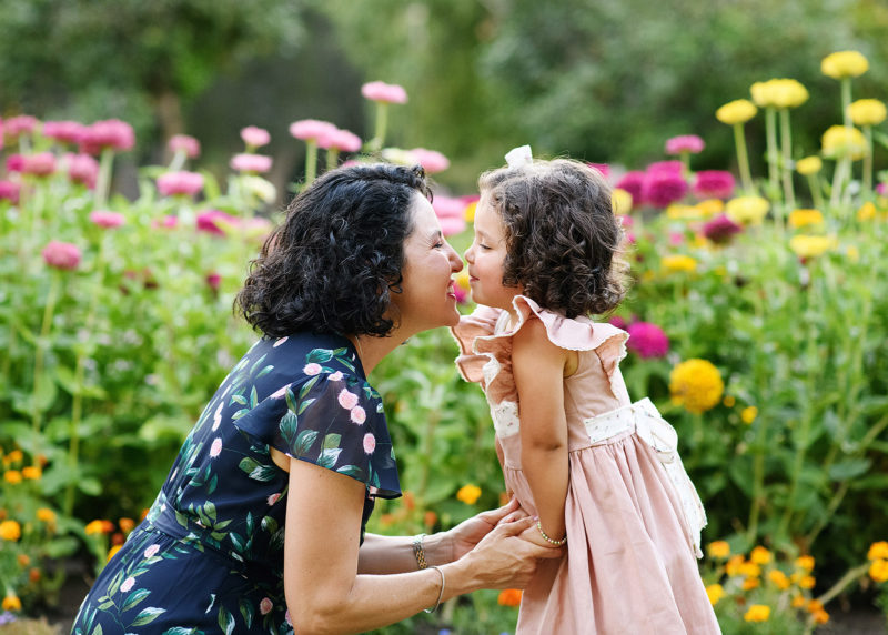 Mom does eskimo kiss to daughter in front of wildflowers at Sacramento Capitol