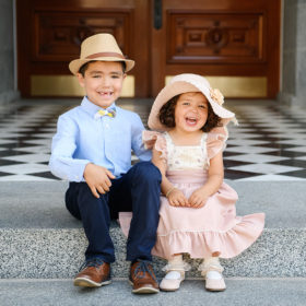 Brother and sister sitting on Sacramento Capitol steps wearing straw hats and smiling