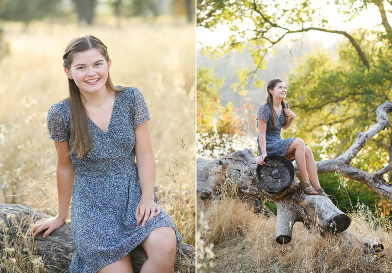 High school senior girl sitting on fallen log in dry grass and framed by tree branch Folsom