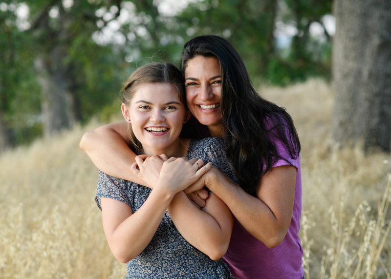 High school senior girl and mom hugging in dry grass field Folsom