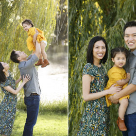 Mom and dad hold toddler daughter and toss her in the air with willow tree in background