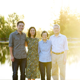 Parents and grandparents smile in front of the lake during sunset in Bywater Hollow Lavender Farm