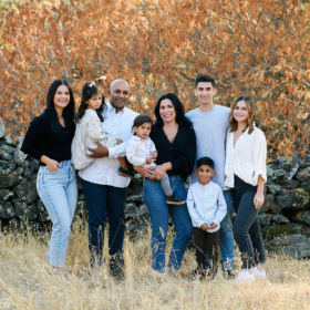 Large family photo with teens and toddlers wearing neutrals against fall foliage in Sacramento