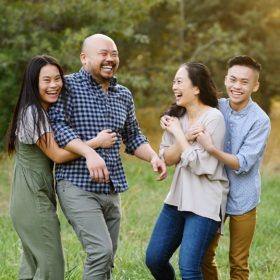 Asian family laughing and hugging each other during golden hour in Sacramento