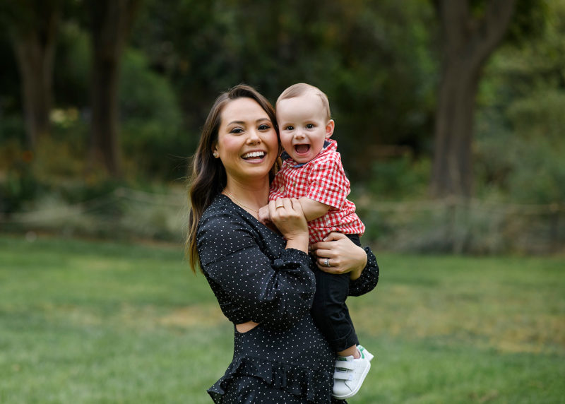 Mom smiling while holding smiling son in Sacramento park