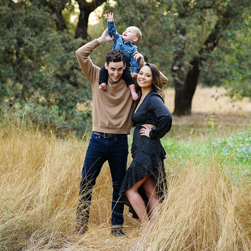 Dad holding up son on shoulders in dry grass in Sacramento