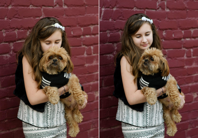 Little girl holding dog dressed up in tuxedo in front of red brick wall in Sacramento