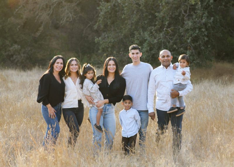 Large family poses for a picture in dry grass field