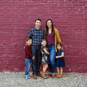 Family picture in front of purple brick wall in midtown Sacramento