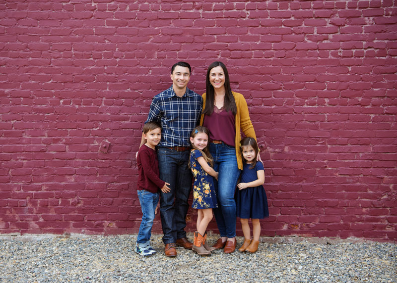 Family picture in front of purple brick wall in midtown Sacramento