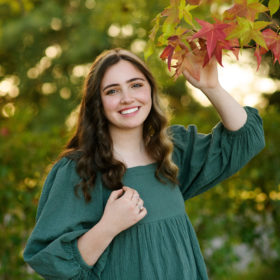 Teen girl holding red maple leaf in Bywater Hollow Lavender Farm in Lincoln