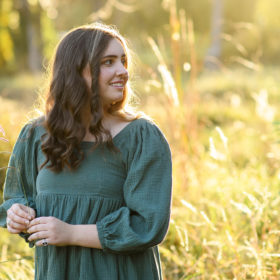 High school senior girl during sunset holding a reed in Bywater Hollow Lavender Farm in Lincoln