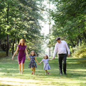 Family holding hands and walking through park surrounded by trees at Empire Mine State Park