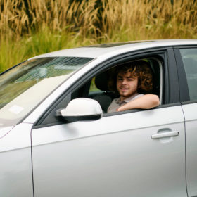 Teen boy inside silver car driving in Sacramento