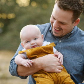Close up of dad holding son in Sacramento dry grass