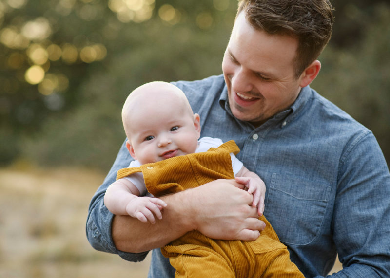 Close up of dad holding son in Sacramento dry grass