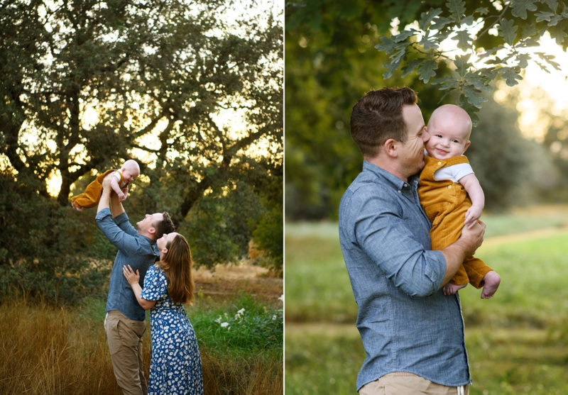 Dad holding up baby boy in the air with large oak tree in background during sunset in Sacramento