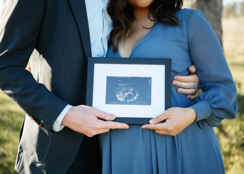 Pregnant couple holding a picture of ultrasound in Auburn
