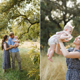 Mom holding baby girl up and smiling with trees and dry grass in background in Davis