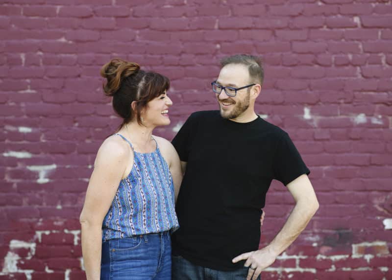 couple laughing with red brick wall in downtown sacramento california