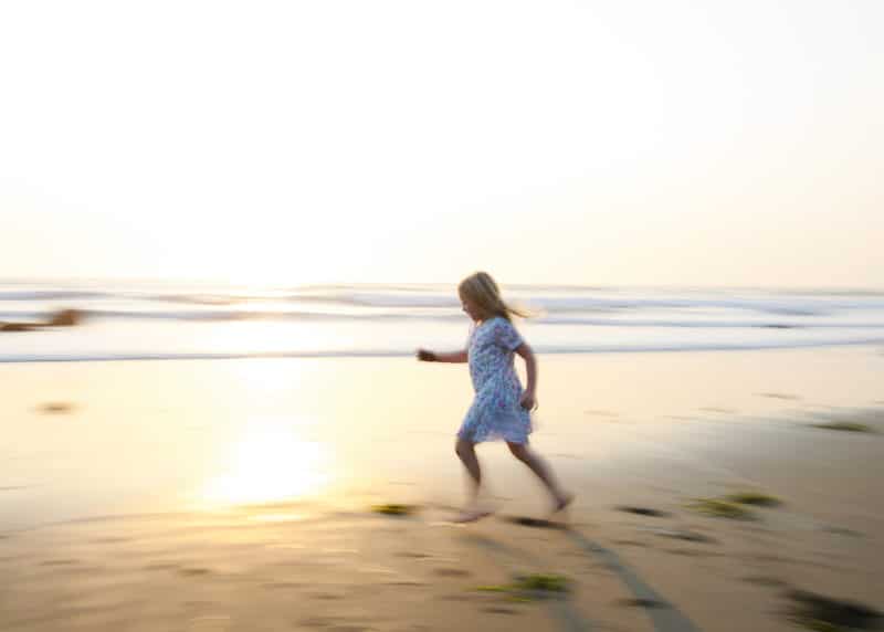 girl running on the beach at sunset dillon beach california