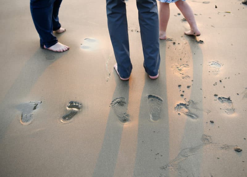 family ocean photo shoot footprints in the sand dillon beach california during sunset