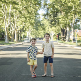 brothers holding hands in street in east sacramento california summer