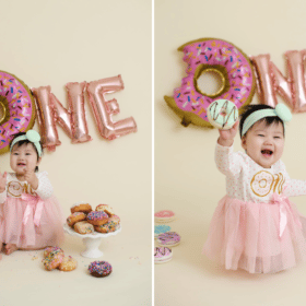 one year old girl with pink donuts in studio photoshoot cake smash smiling and clapping