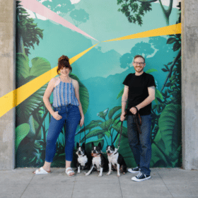 couple in front of mural in downtown sacramento with boston terriers