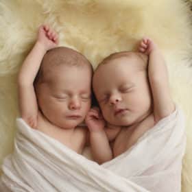 twin newborn baby girls in a blanket studio photo shoot