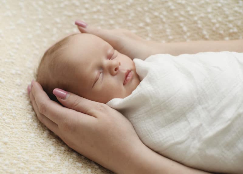 newborn baby girl sleeping in a studio photo shoot 