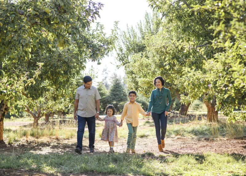 family holding hands in an apple orchard in the fall sacramento california