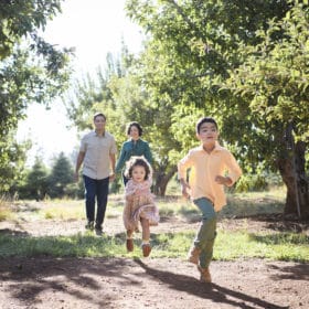 family running through apple orchard fall photos in sacramento california