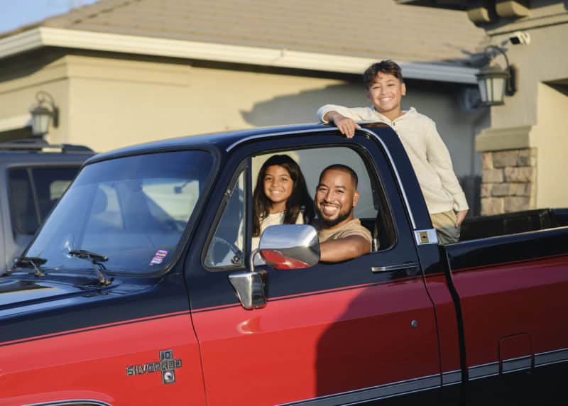 dad and kids sitting in the truck at home family photo shoot