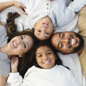 family laying on the ground smiling in family photo shoot sacramento california