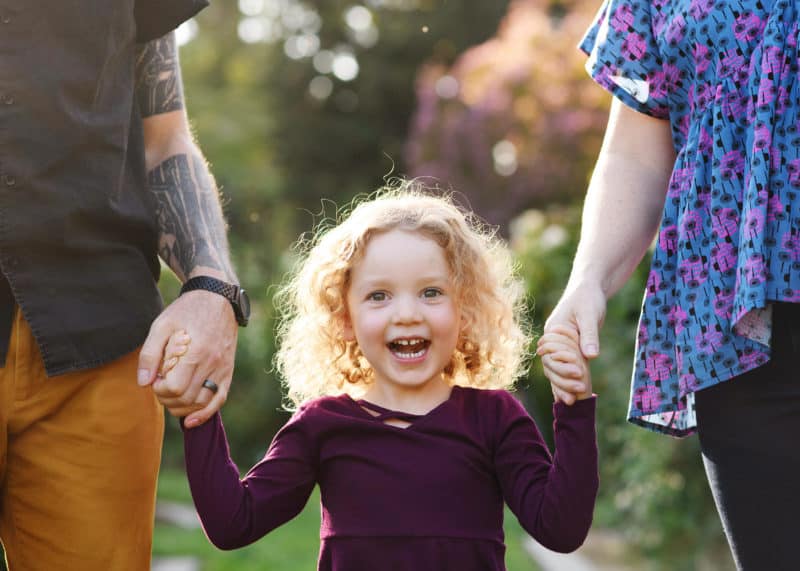 young girl smiling during family photo shoot in rose garden in sacramento california