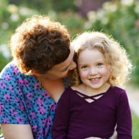 young girl with mom during family photo shoot in rose garden sacramento california