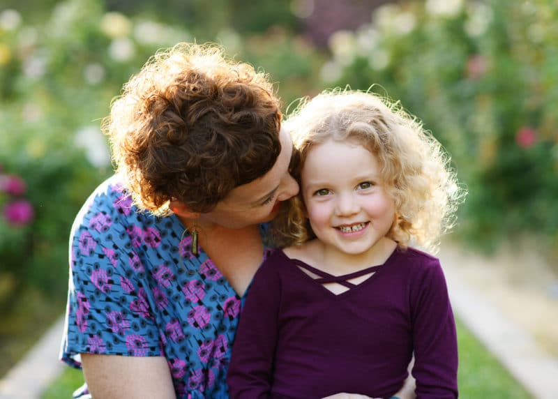young girl with mom during family photo shoot in rose garden sacramento california