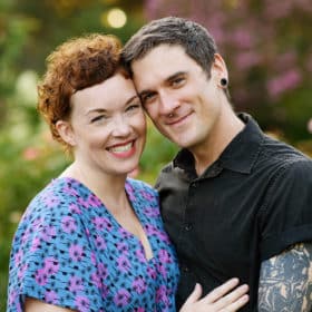 couple smiling during family photo shoot in the rose garden sacramento california