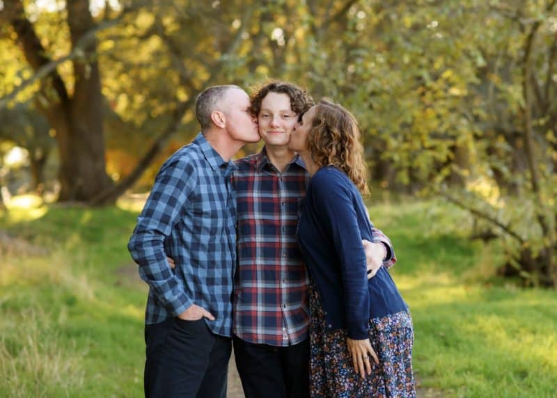 mom and dad kissing son on the cheeks fall photos sacramento california
