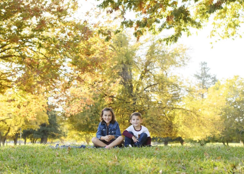 brother and sister posing in the grass fall family photo session rancho cordova california